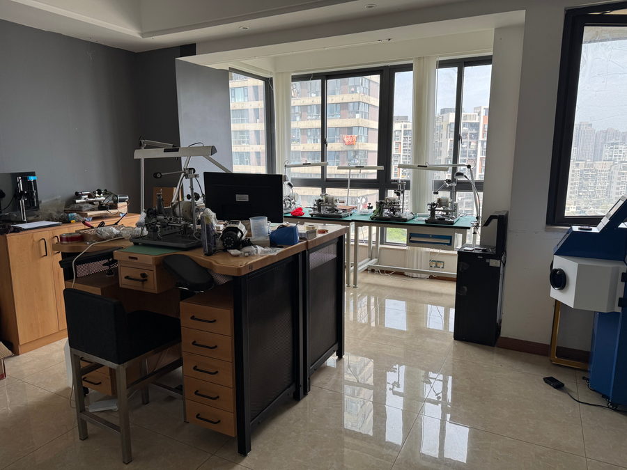 Benches under task lamps beside floor-to-ceiling windows looking out over the city