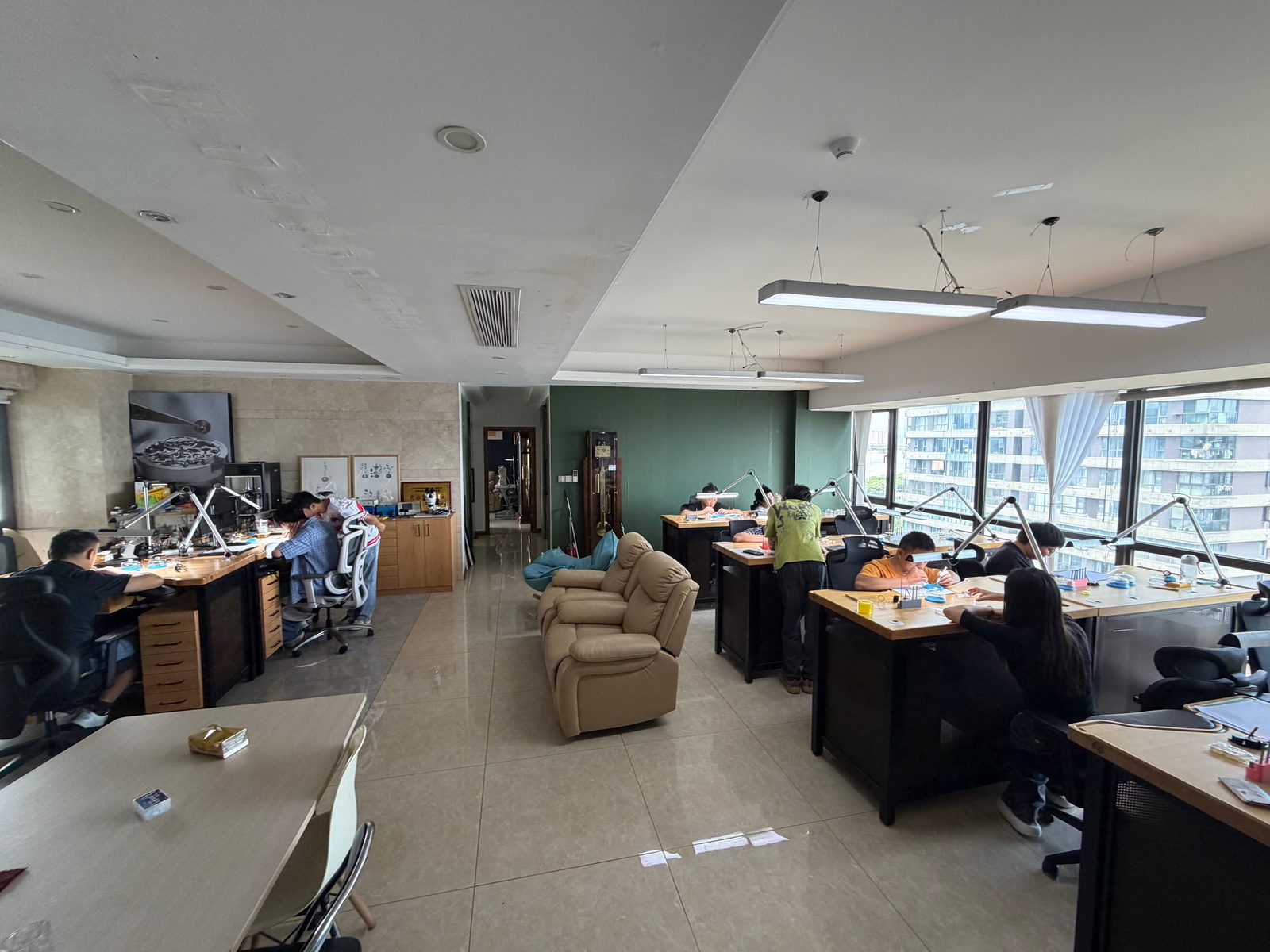 The training floor, with students working at benches on both sides under task lamps